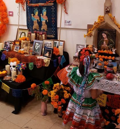 Attendees of all ages and ethnicities are fascinated by the Day of the Dead altars on display in the main building.
